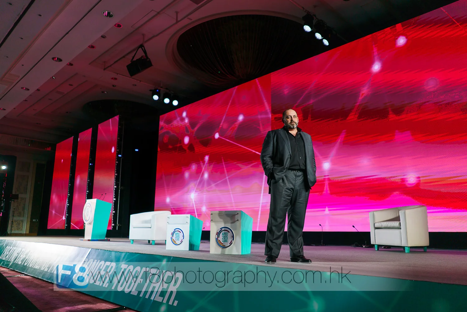 darren kerr from factor168 , project director and executive producer for apec 2015 checks the layout, visuals and sound setup on stage at the end of day 2 of the summit.