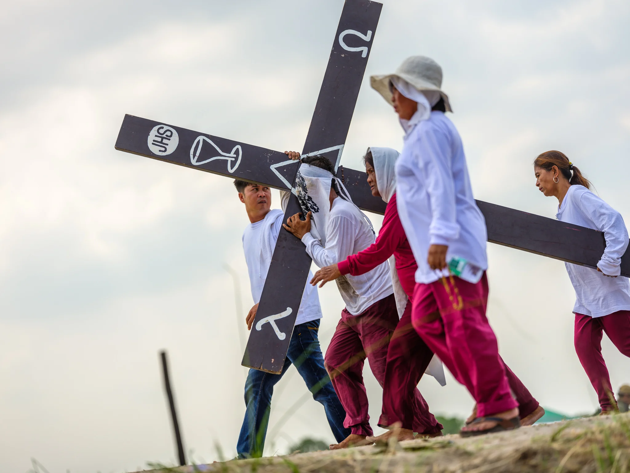 Devotee penitents carry heavy wooden crosses for several kilometres up to the crucifixion site atop a hill outside san pedro cutud, pampanga. Fuji GFX, 110mm.