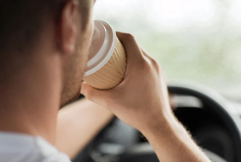 man drinking coffee while driving the car.jpg