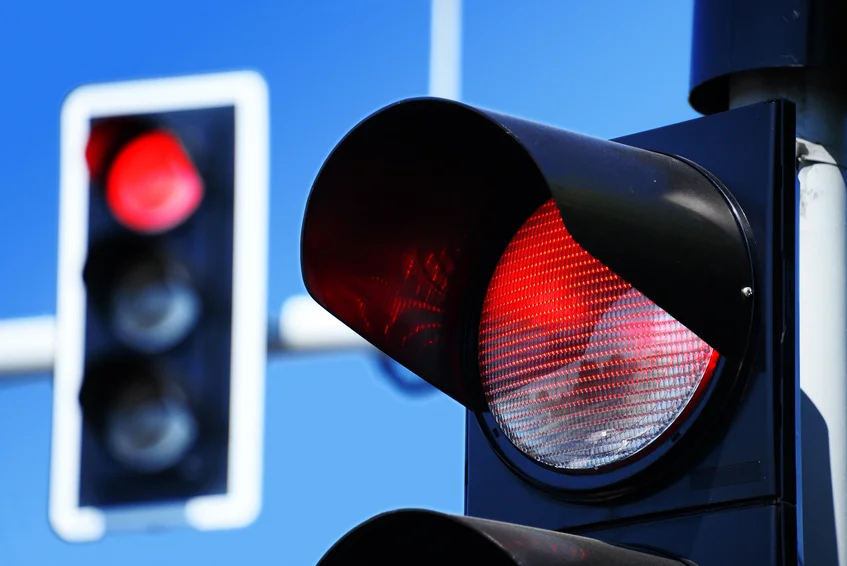 Traffic lights against blue sky showing red signal