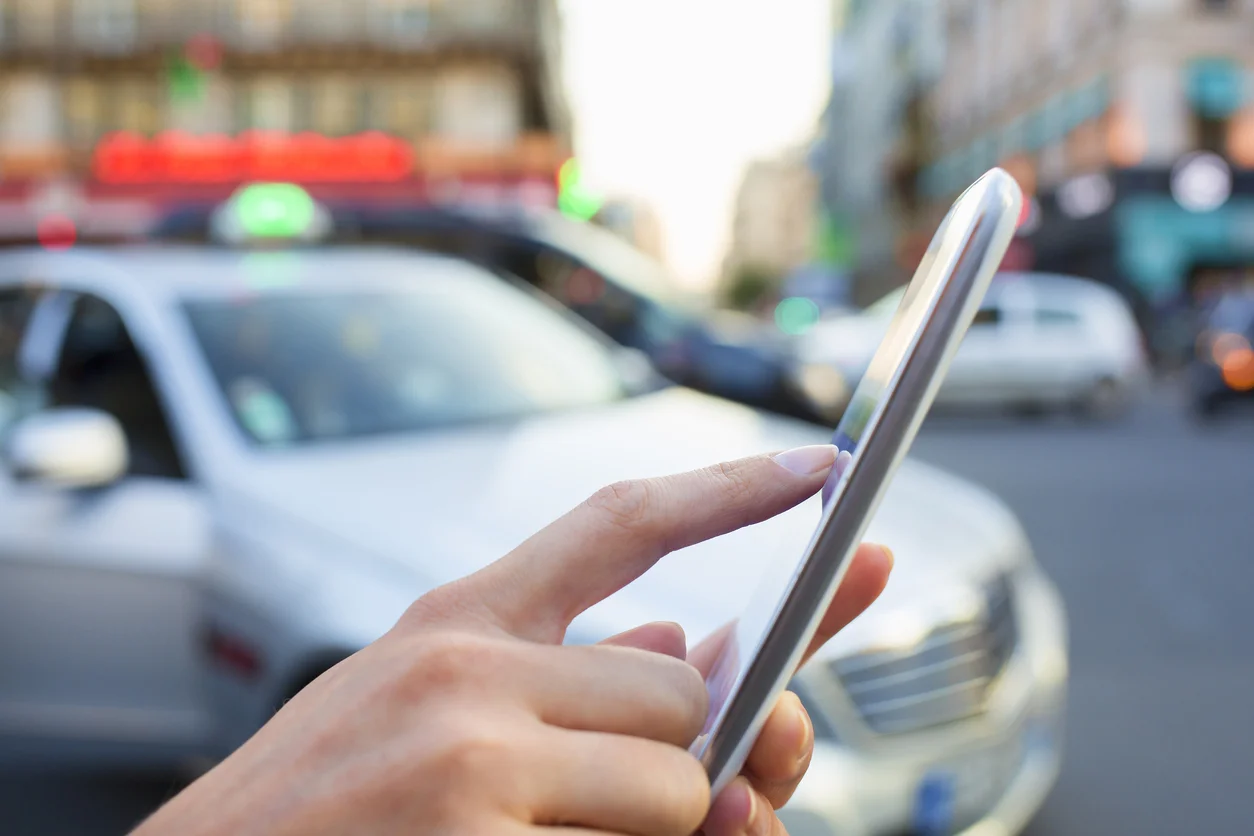 A woman orders a taxi on her mobile phone