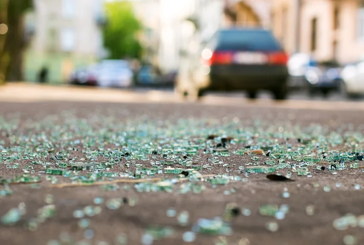 Close-up image of broken glass on the road after a car accident