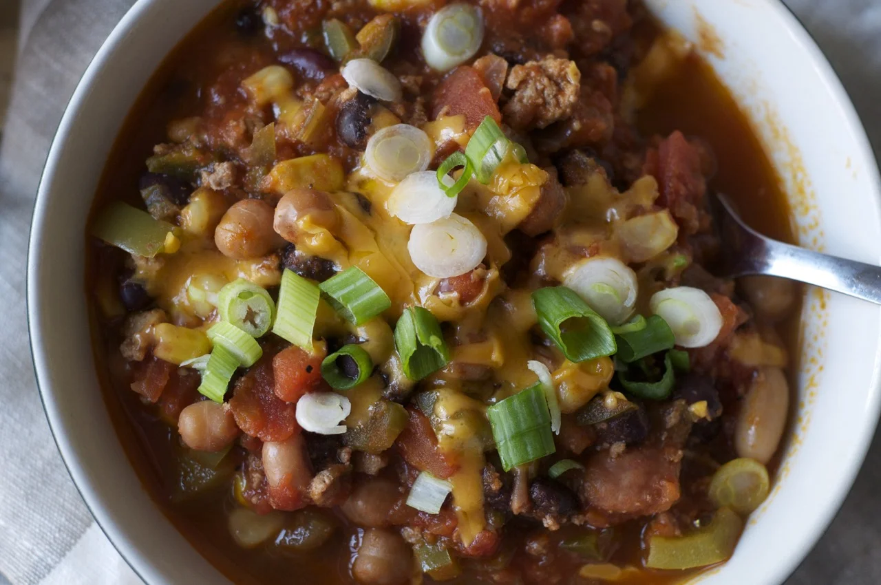This meal is perfect to let simmer away while you’re at work; the longer the flavours cook together, the better it tastes. It can also be made on the stove-top if you don’t have access to a slow-cooker - the benefit to the slow cooker is the bigger the batch, the better as this freezes well for later use, and is great for meal planning for your week. Topped with freshly cut green onions and a sprinkle of low-fat cheddar cheese, this chilli is perfect healthy comfort food.