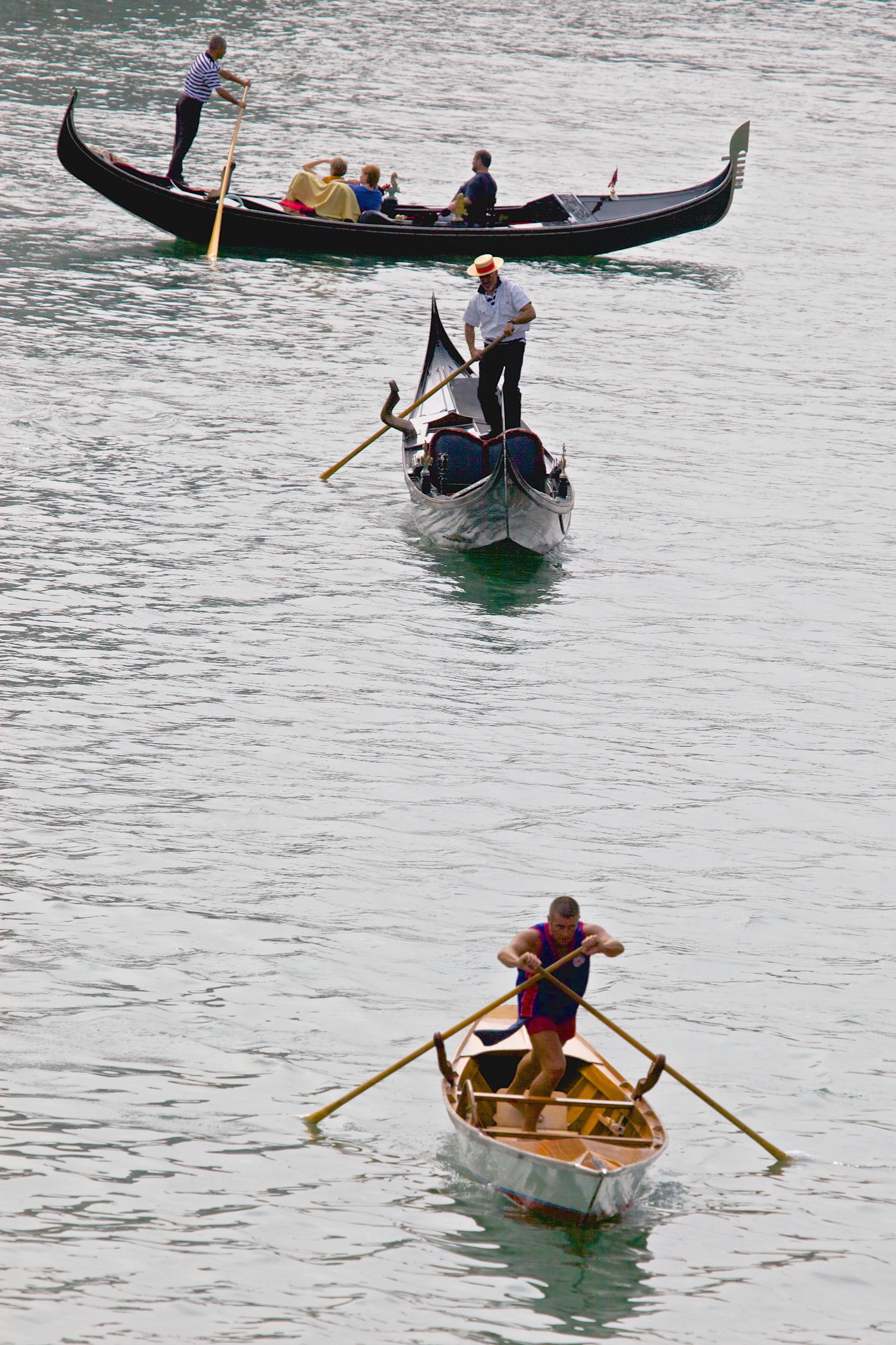 Different rowing techniques while crossing the Canale Grande in Venice.