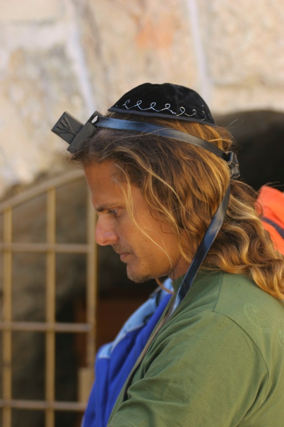 Using a tefillin to communicate with the Almighty for better reception. Jerusalem, Israel.