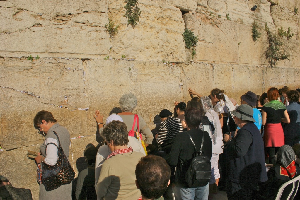 Worshippers inserting prayers on paper in Wailing Wall cracks. Jerusalem, Israel.