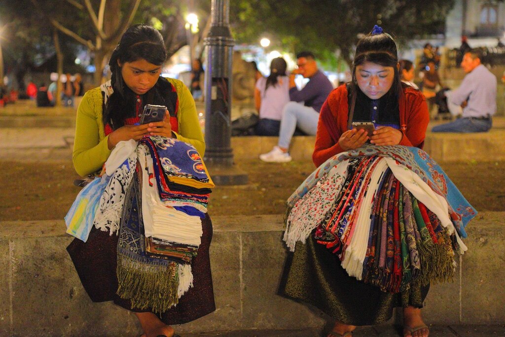 Catching up on the gossip on the sites between sales. Oaxaca, Mexico.
