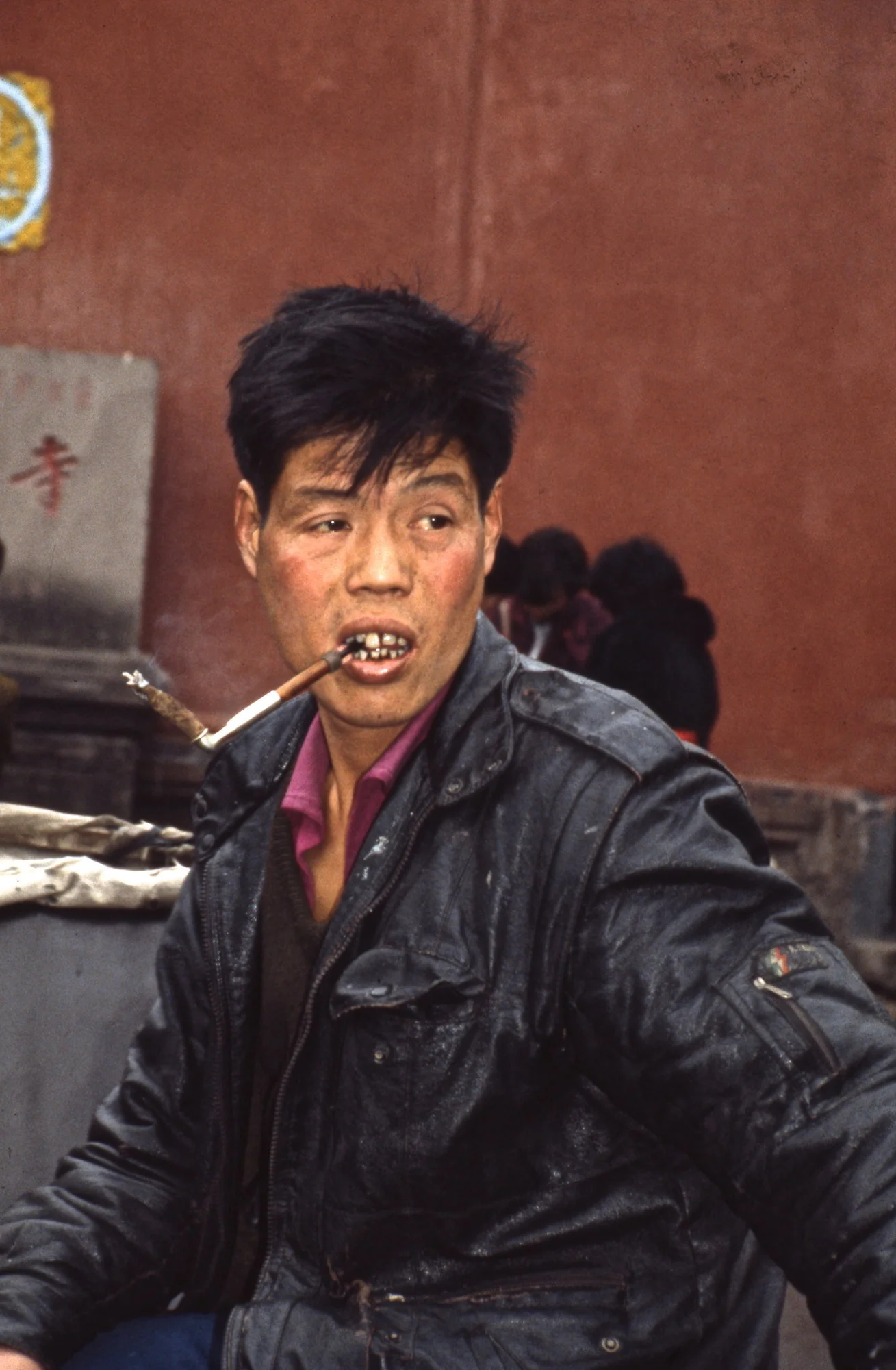 Smoker with typical cigarette-holder, China.