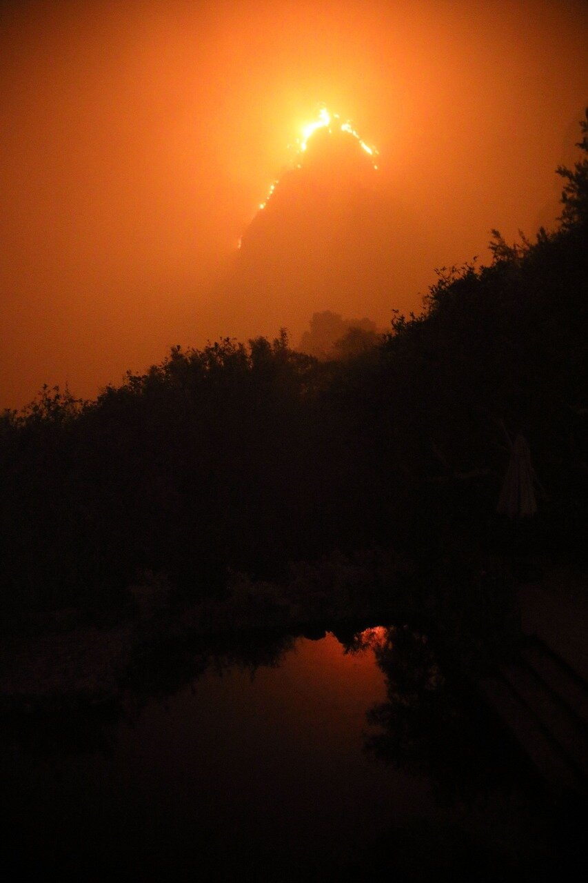 Wildfire in the Tepozteco National Park, Mexico, reflected in a pool of water.