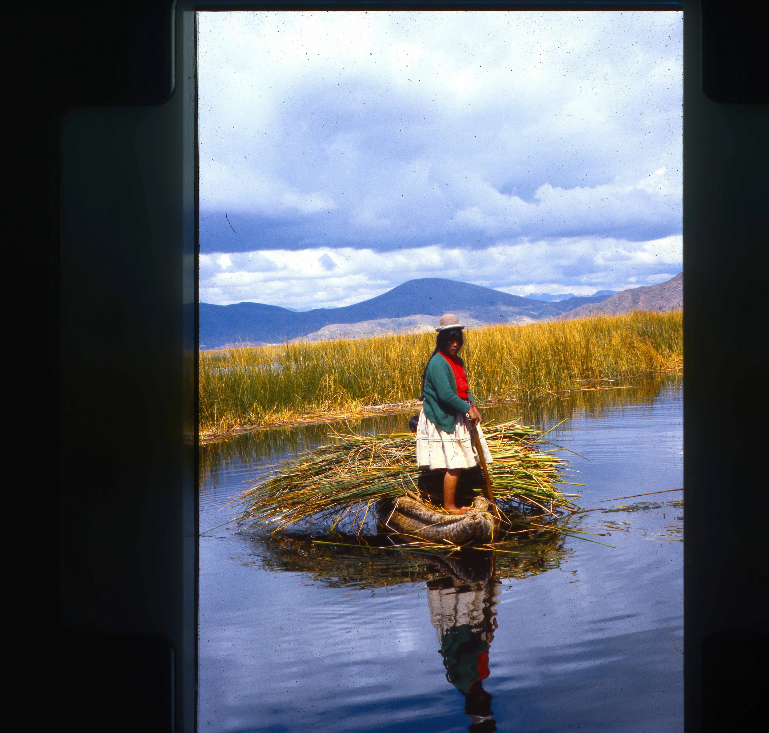 Woman of the Uros tribe – who use use totora reeds for food, transporttion and housing on manmade islands made of the same reeds – rowing across the Titicaca lake in Peru.