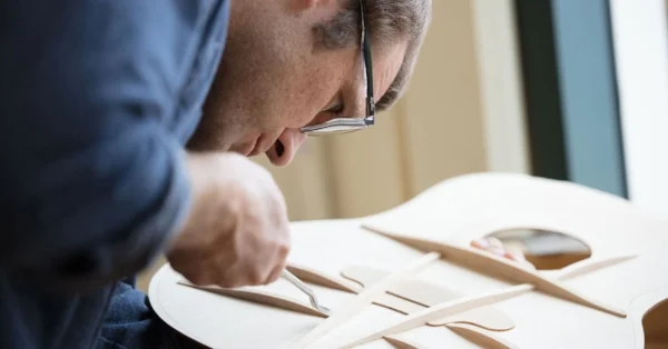 Andy Powers refines a V-Class System build. Photo courtesy of Taylor Guitars.