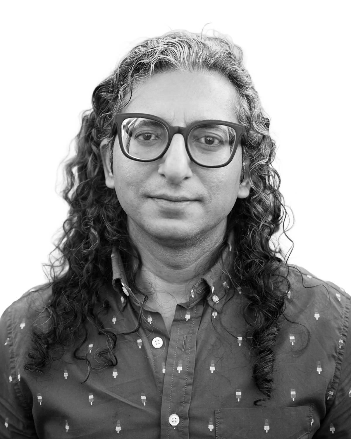 Black and white portrait of Atin Mehra, facing forward with a calm expression, isolated on a transparent background, representing a documentary filmmaker and creative leader at an award-winning film production company.