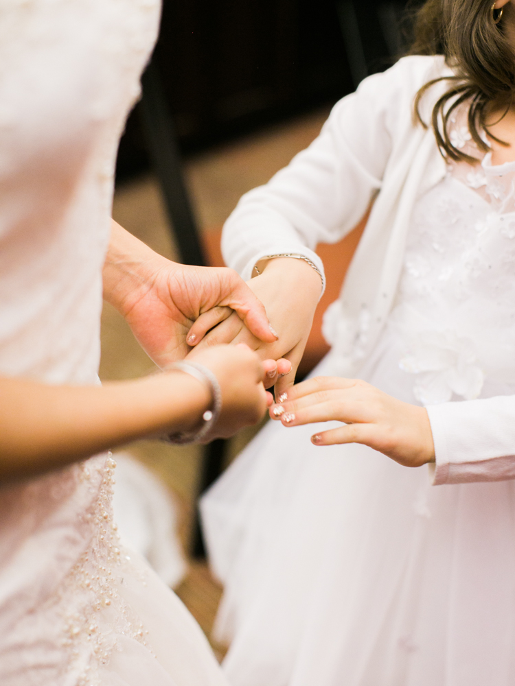 bride holding hands with the flower girl