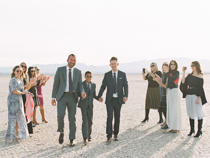 grooms holding hands after ceremony