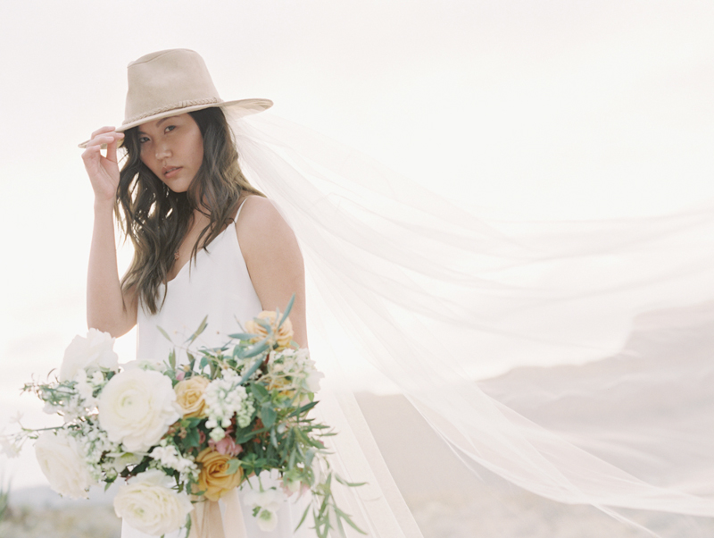 bride wearing cowboy hat and veil desert wedding