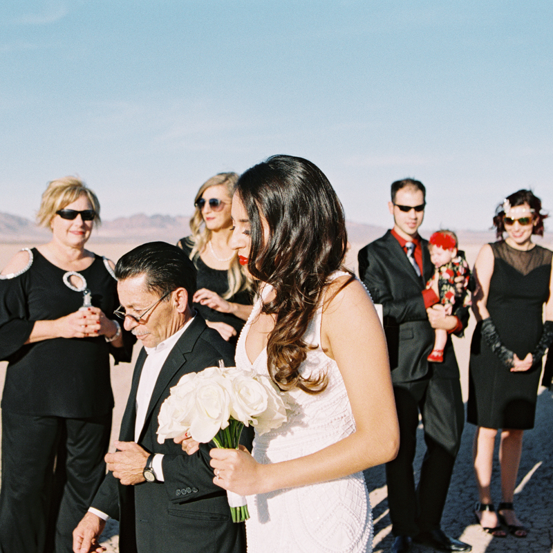 bride walking with dad in the desert