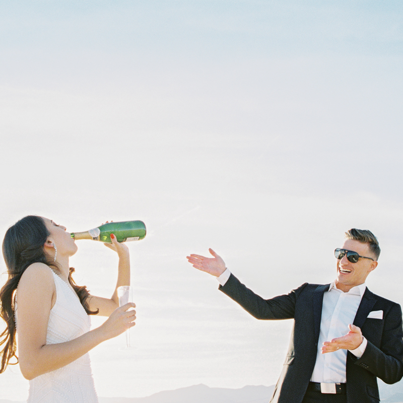 bride drinking champagne out of bottle