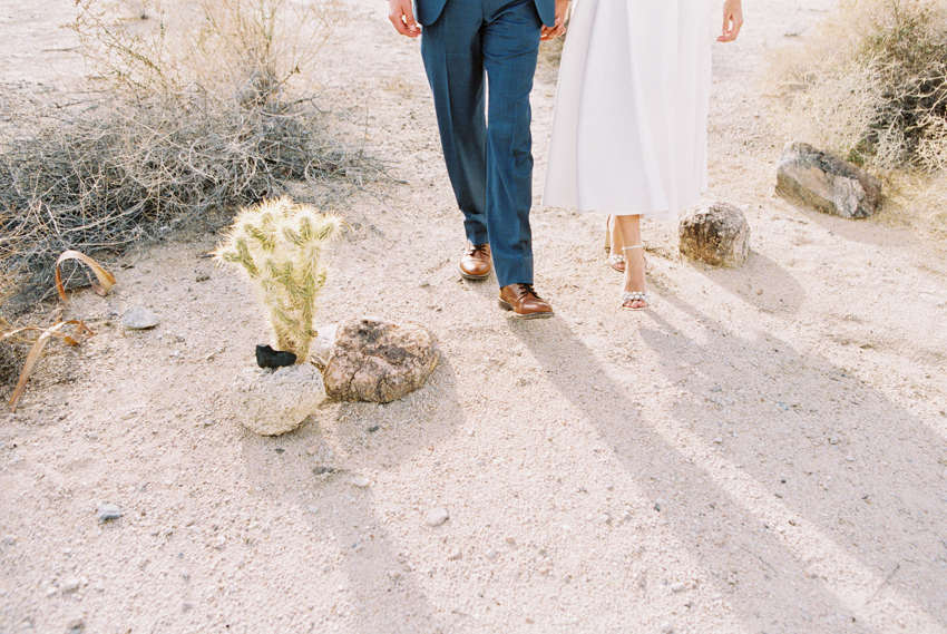 bride and groom walking in the desert