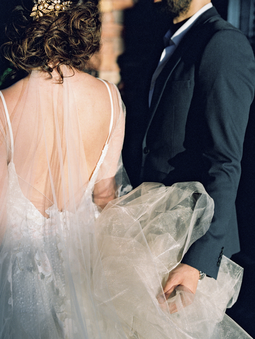 groom helping bride with dress