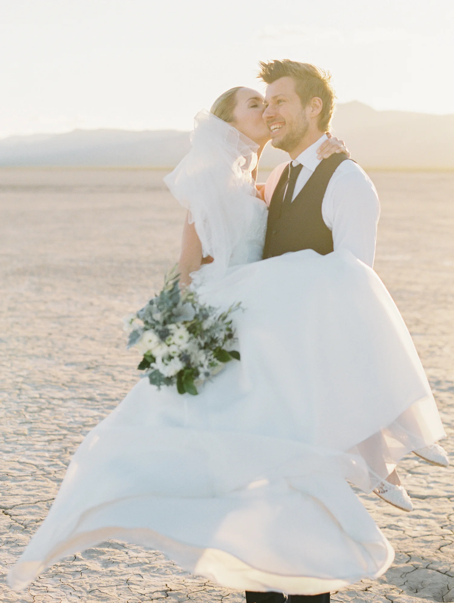 groom carrying his bride