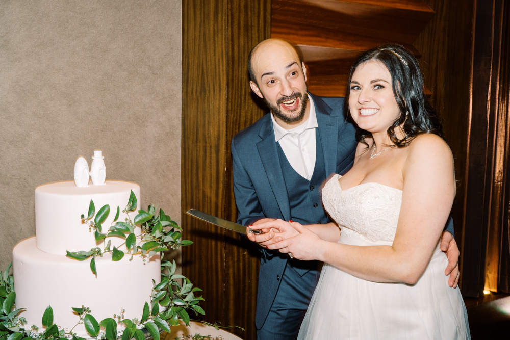 groom surprise expression while cutting wedding cake