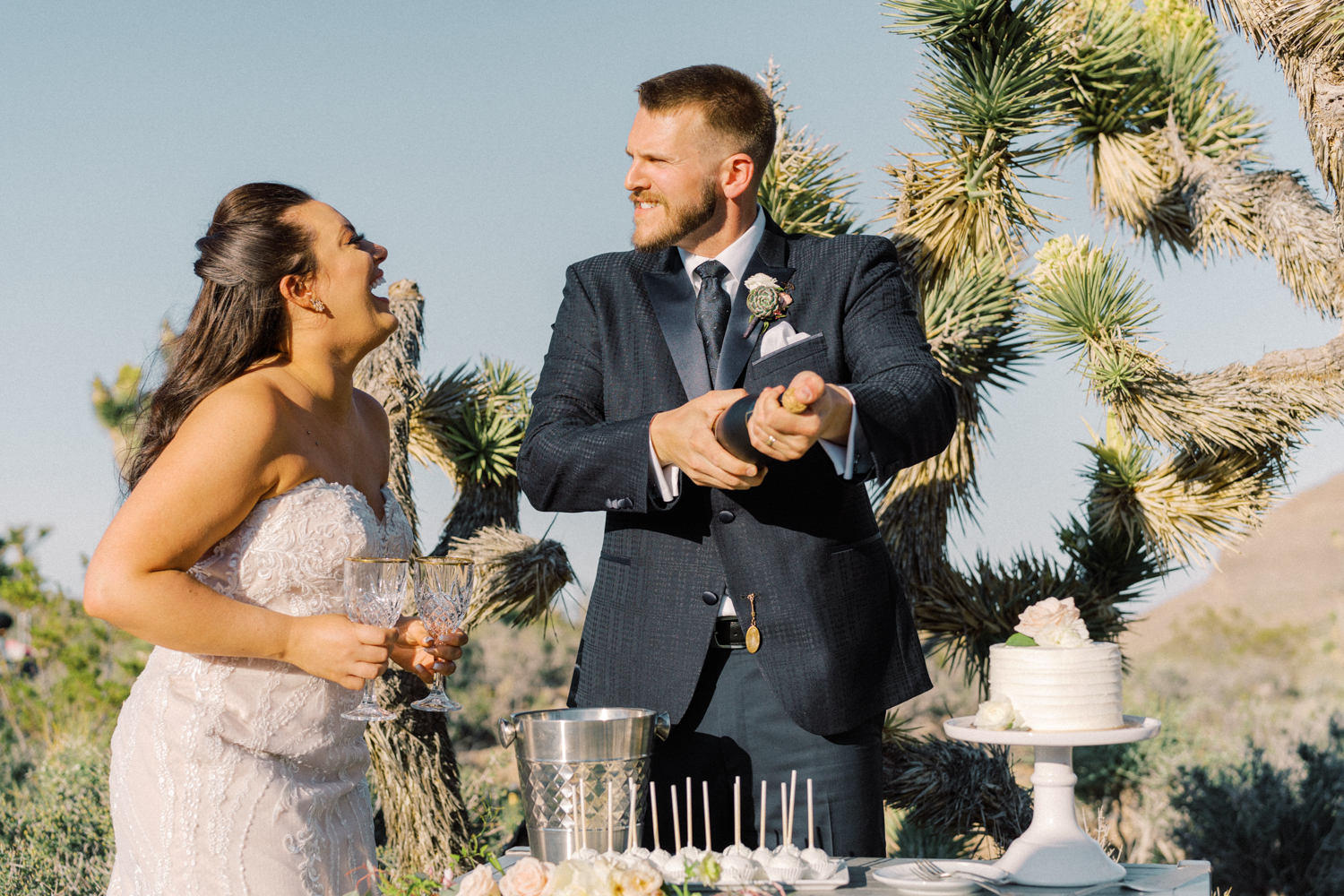 bride and groom popping the champagne outside