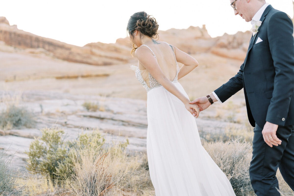 bride and groom walking in the desert