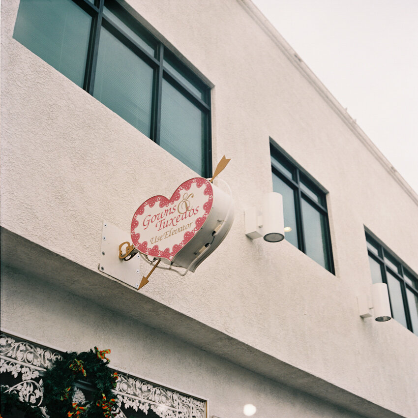 a little white wedding chapel tux and gowns sign