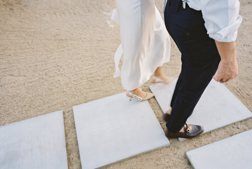 bride and groom walking desert