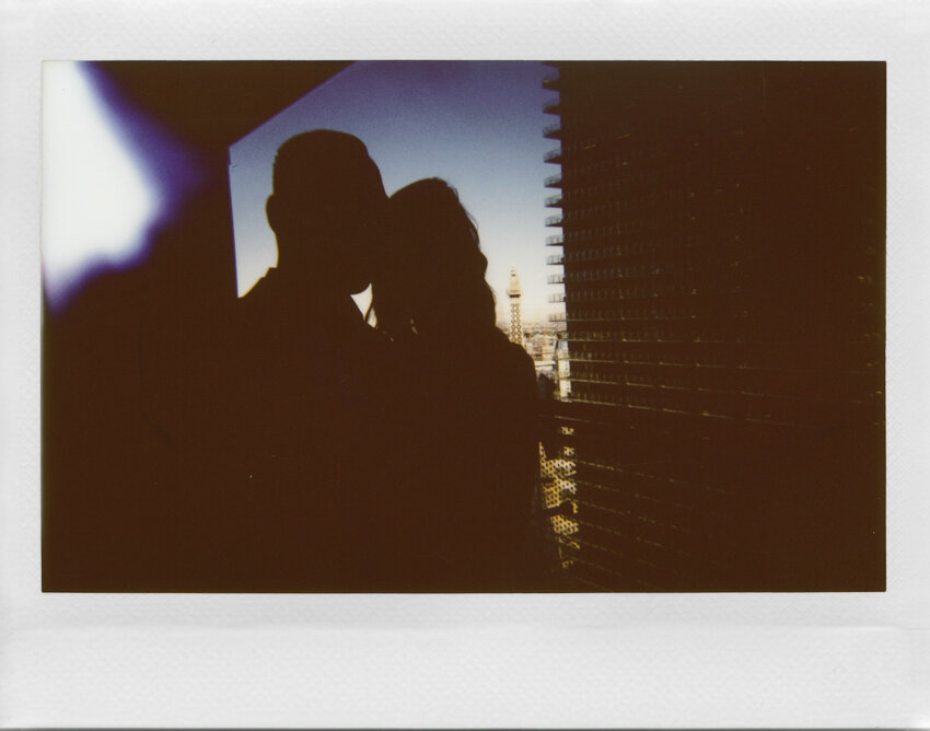 silhouette of bride and groom with city in background