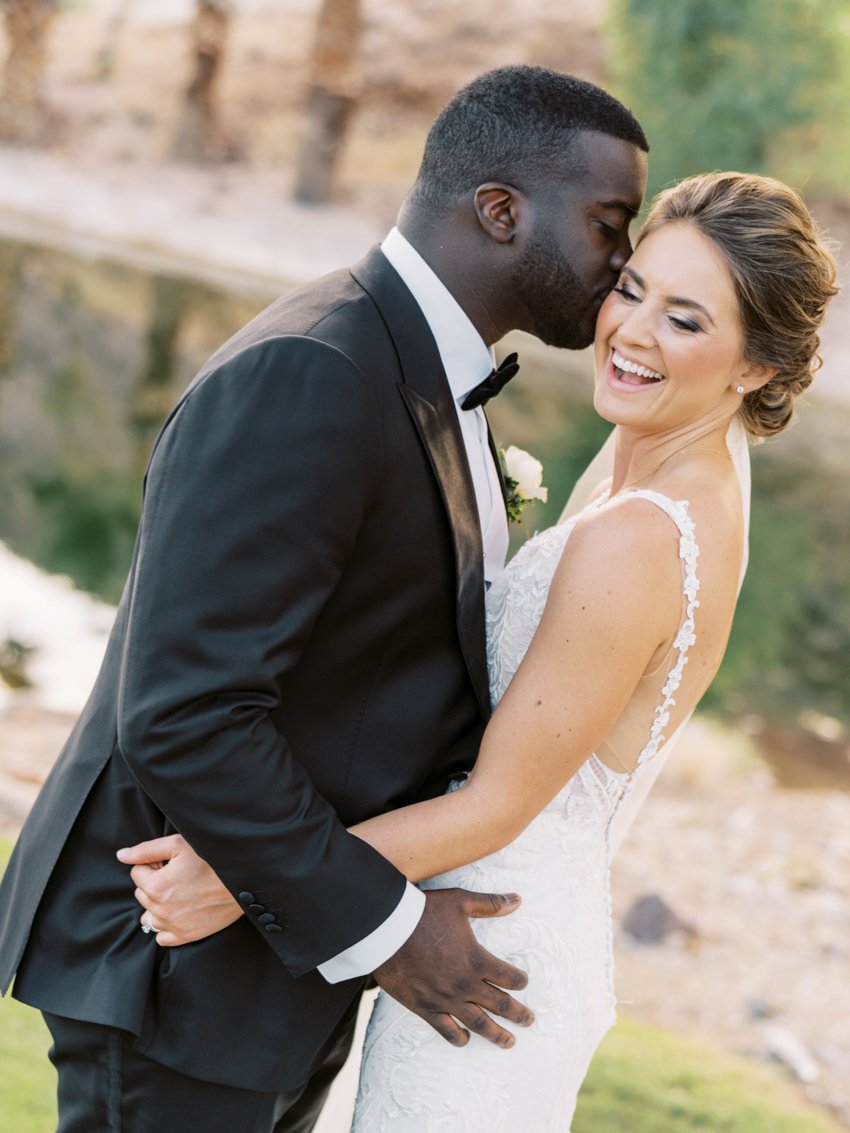 groom kissing bride on the cheek