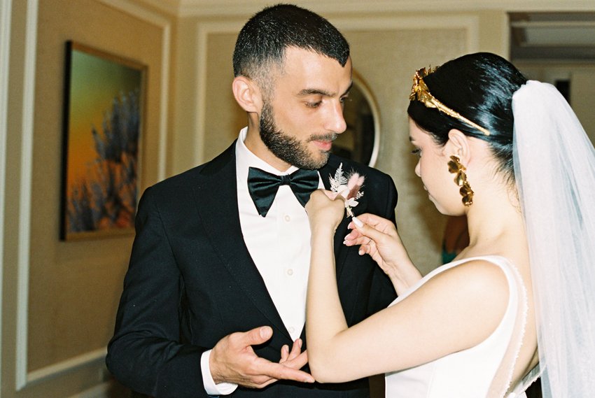 bride putting on boutonnière