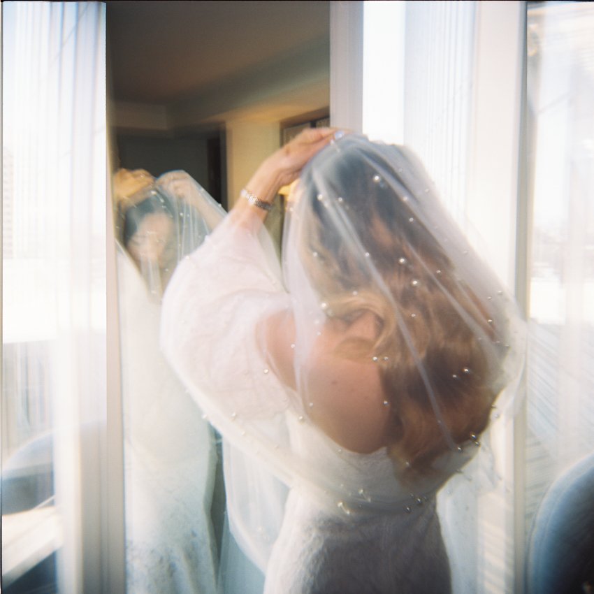 bride putting on veil