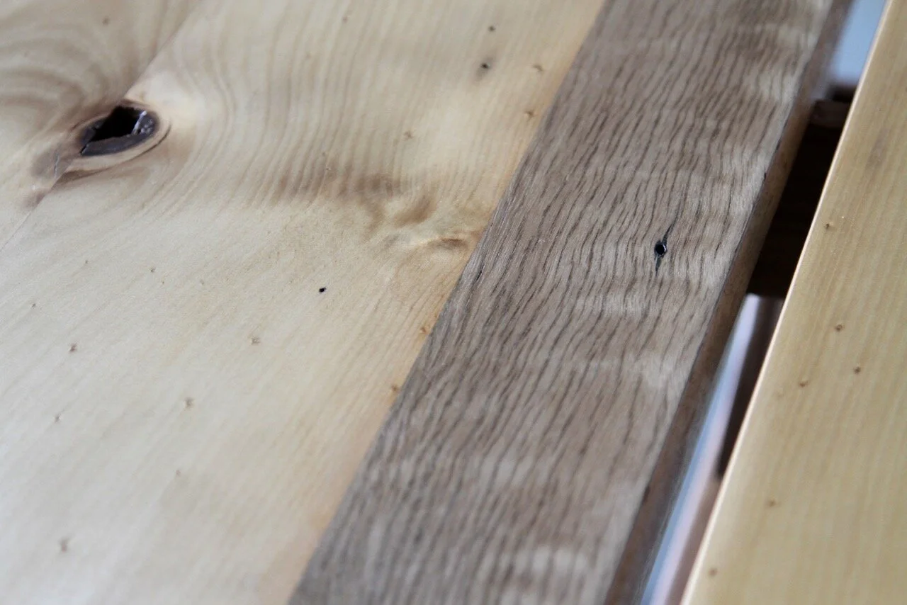 Close-up of wooden planks with natural grain, knots, and varied color tones.