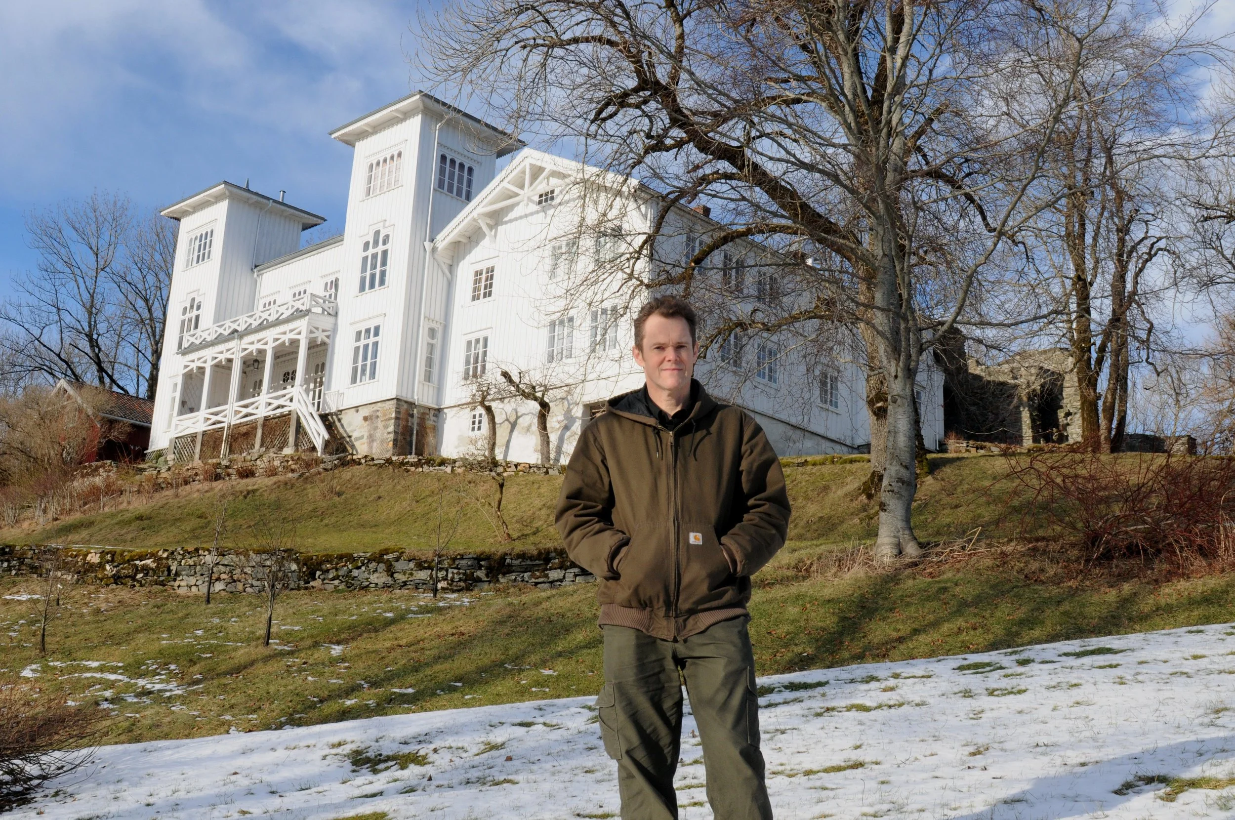 Godseier, gårdbruker og økologisk matprodusent Hans H. Horneman foran hovedhuset.