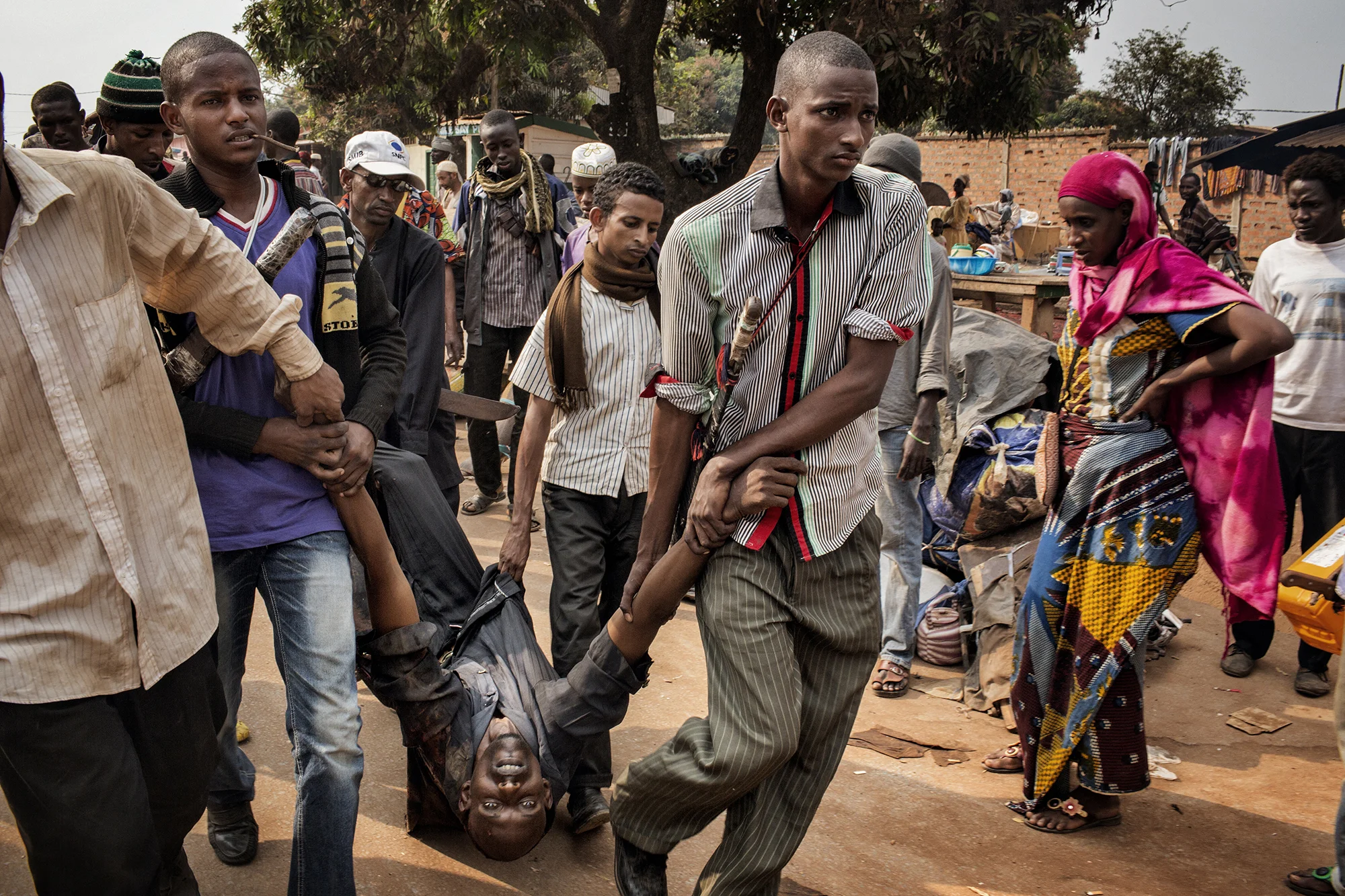 The body of Nana Abdul Karim 34, father of 8 children, is carried back to his home for burial. He was shot, by French soldiers, while buying breakfast for his children. They reported he was demonstrating and firing a weapon at them, but most people in this district have only bows and arrows. The community is being attacked by anti balaka and penned in by french soldiers, they are trying to flee for Chad but there are limited trucks and resources.