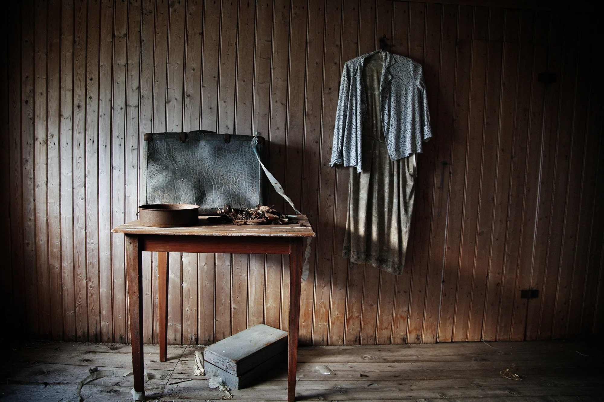 An abandoned home near Grundstad, Lofoten. Inside luggage and clothes remain as if the owner were about to return any moment. The windows and curtains are rotting slowly and the outside has been stripped of any paint. Found opposite the intersection of the streets of Grundstadveien and Hellarhaugen.