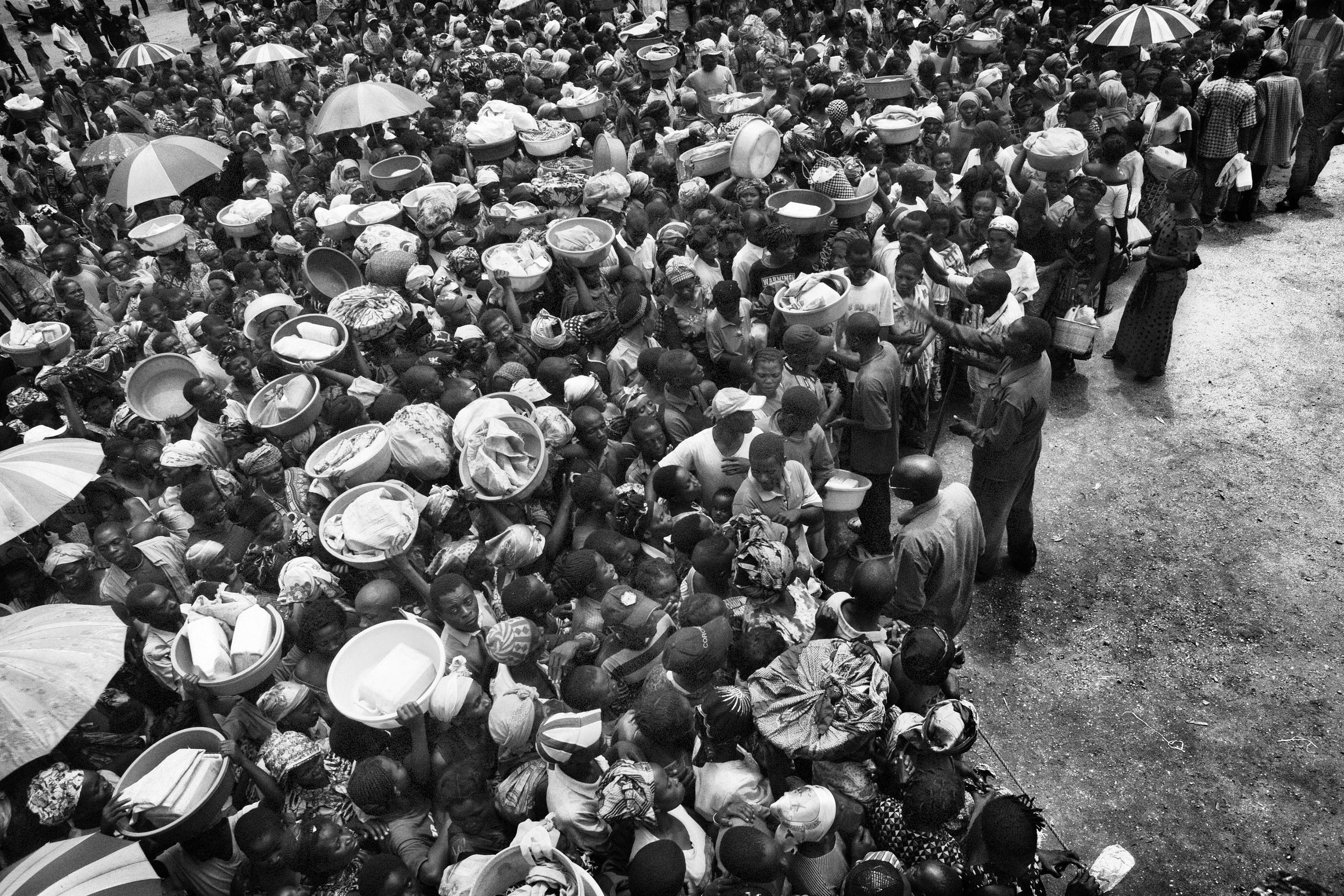 Displaced people in Kiwanja village wait for food handouts from the World Food Program. 2008