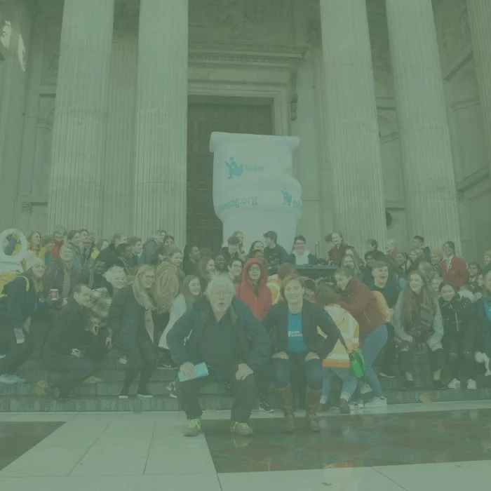 Bill Oddie and people squatting on the steps of St Pal's Cathedral in London with a giant inflatable toilet