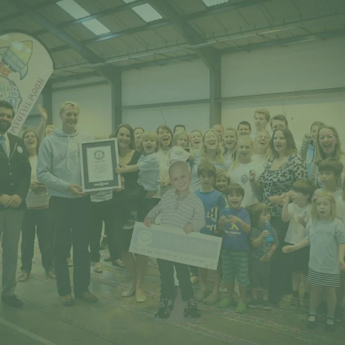 A group of people marking the world record for the world's longest loom band 