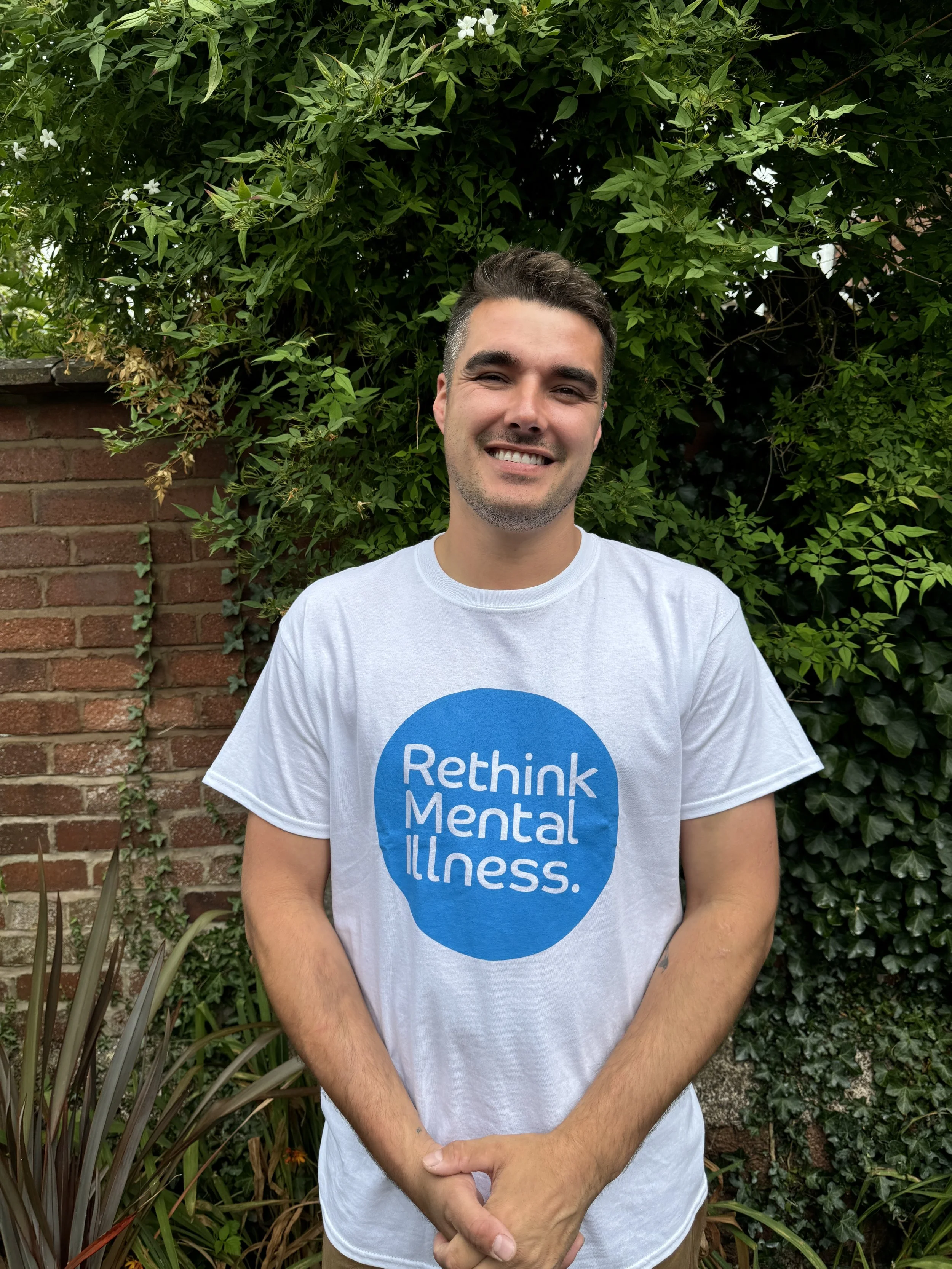Chris Hull supporting Rethink Mental Illness campaign standing in a garden