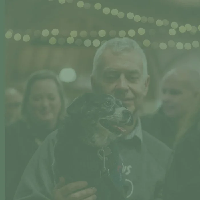 Man holding a dog at.a Christmas concert