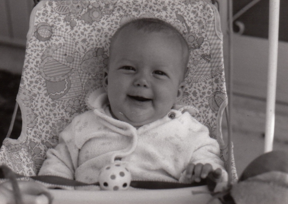 This is a chunky baby version of myself smiling. 