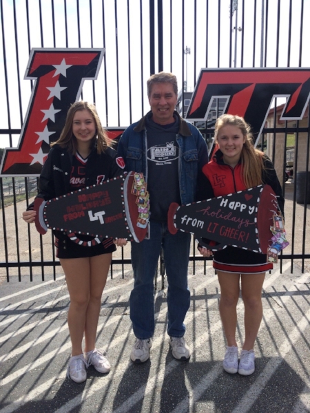 Spencer Smith and Alyssa Bezdek present gift cards to Matt Peacock, the executive director of Partners in Hope.