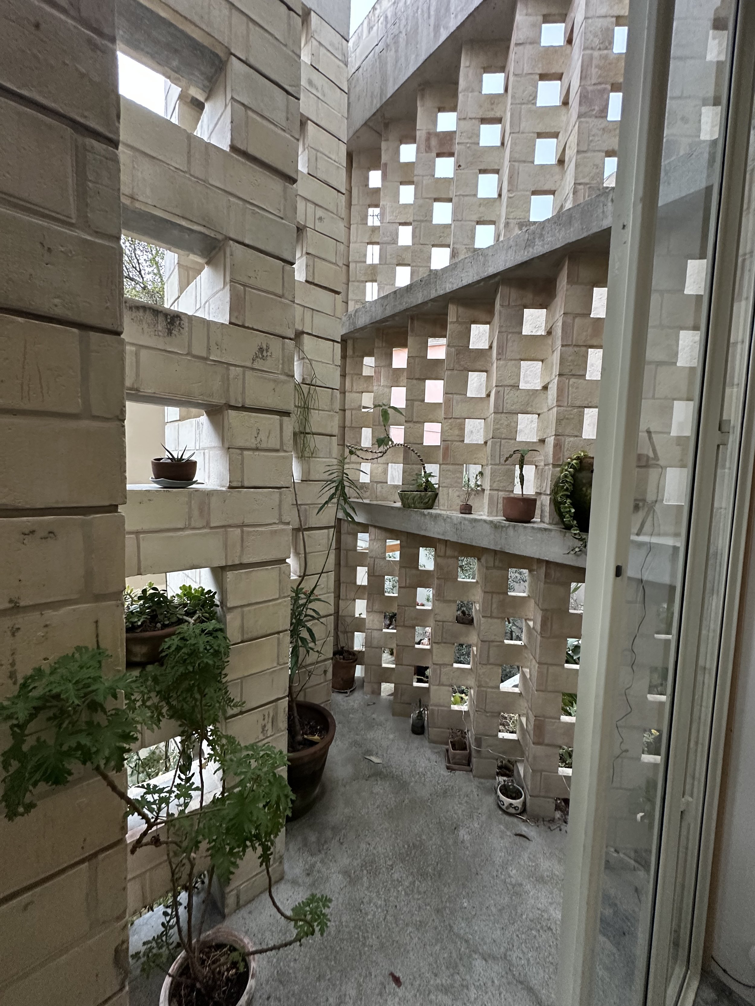 EJT Studio Balcony Between the Glass of the Bulilding and a Brick Screen
