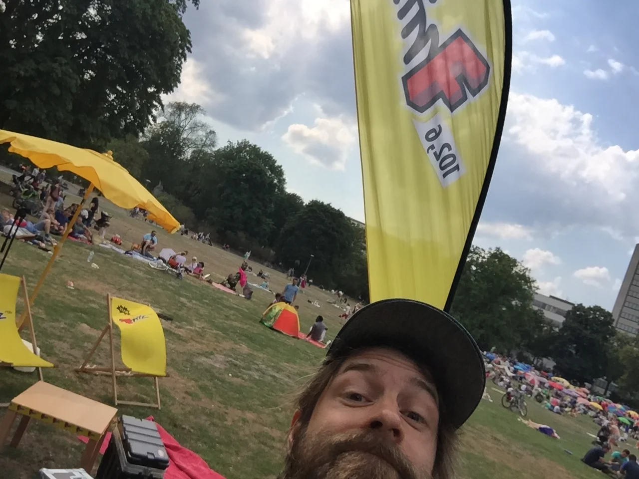 Radiomoderator weiß noch nicht: Schirm im Hintergrund wird gleich wegfliegen.
