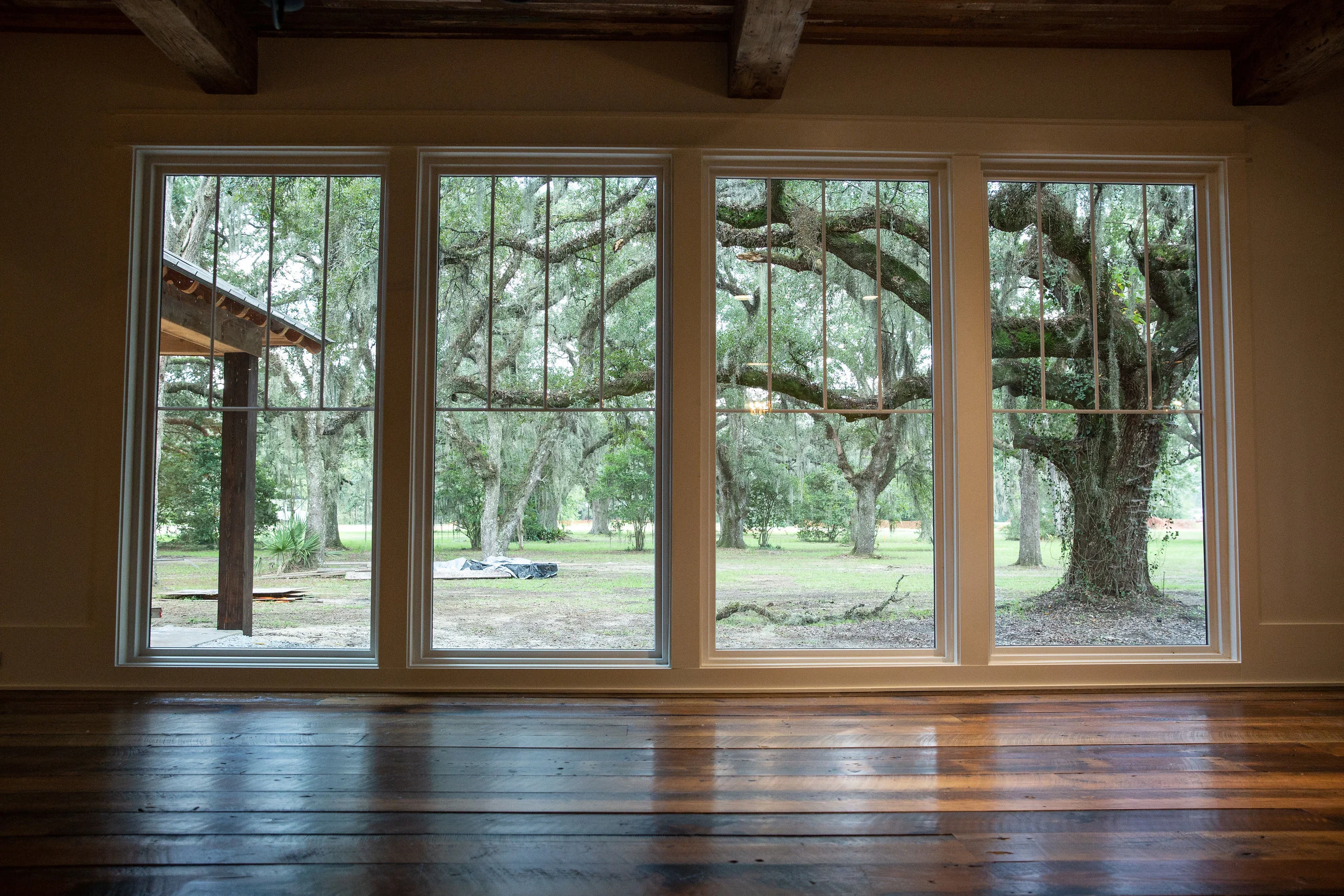 Floor-to-ceiling windows frame a stand of majestic live oaks—a reminder that despite its ingenious design flourishes, this Creole cottage is right at home in South Louisiana.