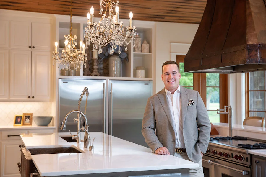 Storm helped his client updated their kitchen, a central family gathering spot with Restoration Hardware chandeliers, new countertops and backsplash, and incorporated the existing custom copper hood into the design. Talk about impact!