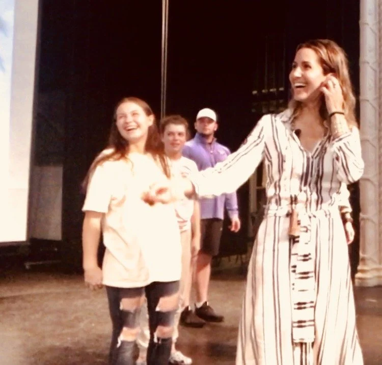 Goli Gabbay smiling on stage with students during an interactive keynote