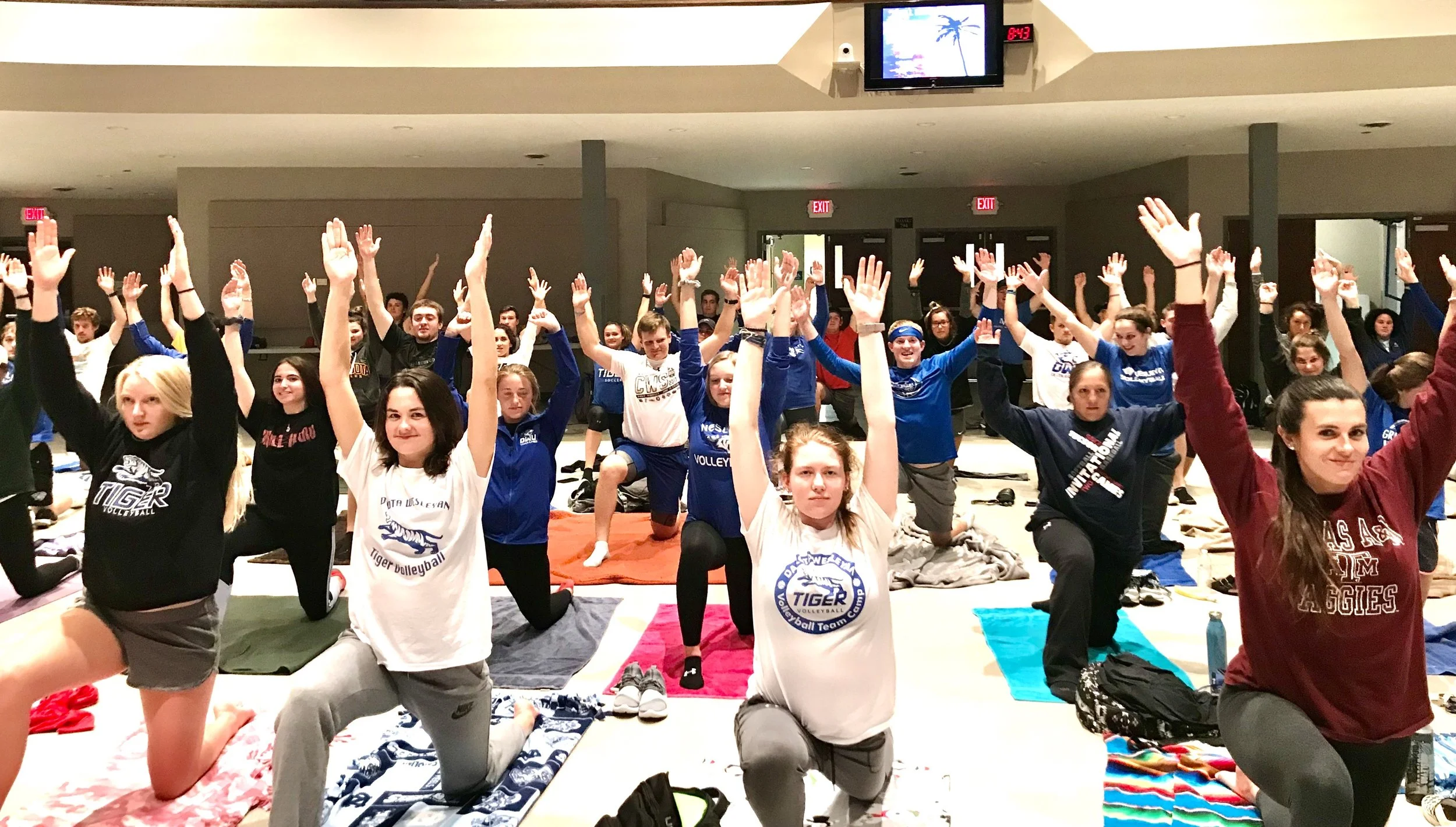 Students raising their arms in joy during Goli Gabbay’s wellness session